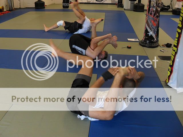 Yoga Students at Third Law BJJ and MMA in Naples, Florida work on putting their legs behind their head